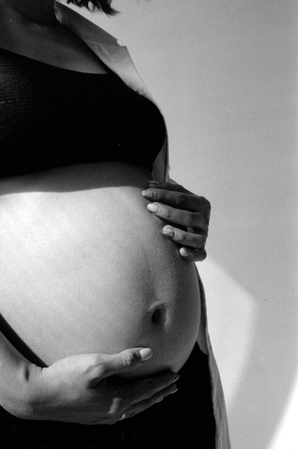 Close da barriga de uma gestante, foto em preto e branco